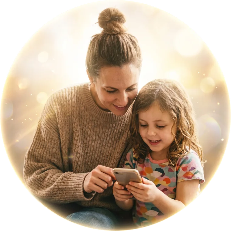 A smiling mother and her daughter looking at a phone together